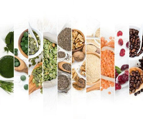 Superfood Mix Slices A variety of healthy foods, including green powders, seeds, nuts, grains, beans, lentils, dried cranberries, and coffee beans, arranged in vertical sections on a white background.