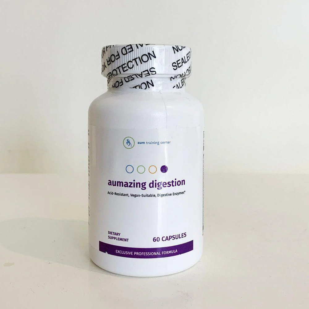 White bottle labeled "aumazing digestion" dietary supplement with 60 capsules, featuring a sealed cap, on a plain light surface.