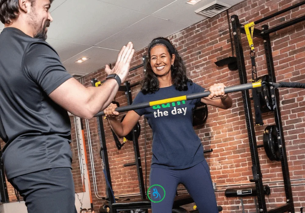 Personal trainer coaching client through strength training session at AUM Training Center in Boston